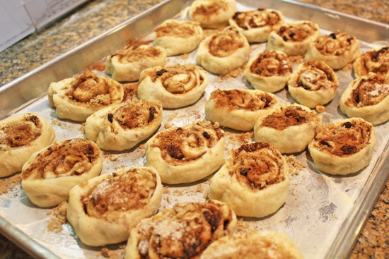 Pinwheels are spaced far apart on a well buttered baking sheet. 